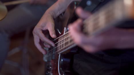 slow motion close up of an electric bass guitar being played finger style during a recording session with a slow vibrating string