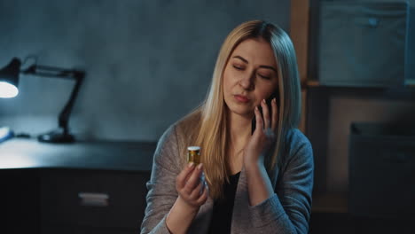 suspecting lady with smartphone holds medicine bottle