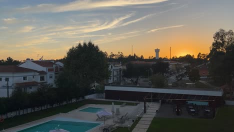 time-lapse of swimming pool outdoors area yard, dusk falls slowly, car traffic visible on nearby road