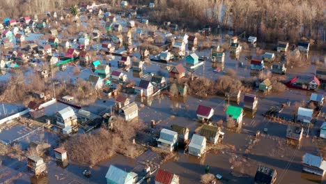flooded cottages and houses during the spring high water, april. trees flooded with water in the background. climate change concept.