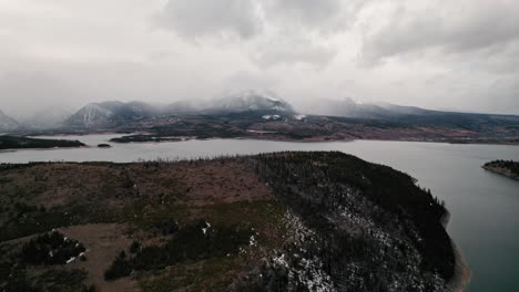 Vista-Aérea-De-Drones-Nublados-Y-Malhumorados-Que-Vuelan-De-Regreso-Desde-La-Colina-Junto-Al-Lago-Cerca-Del-Embalse-De-Dillon-De-Sapphire-Point,-Colorado-En-Un-Día-Nublado