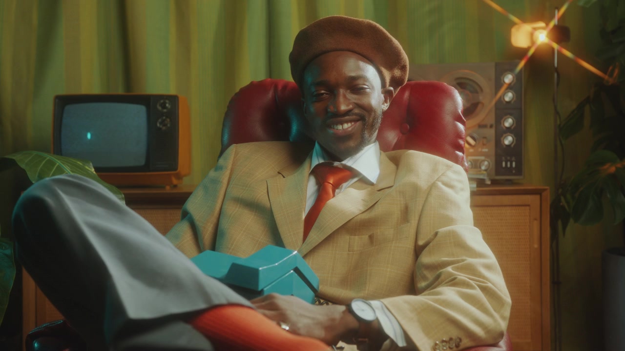 Uomo afroamericano con un sorriso sicuro in posa in uno studio retrò