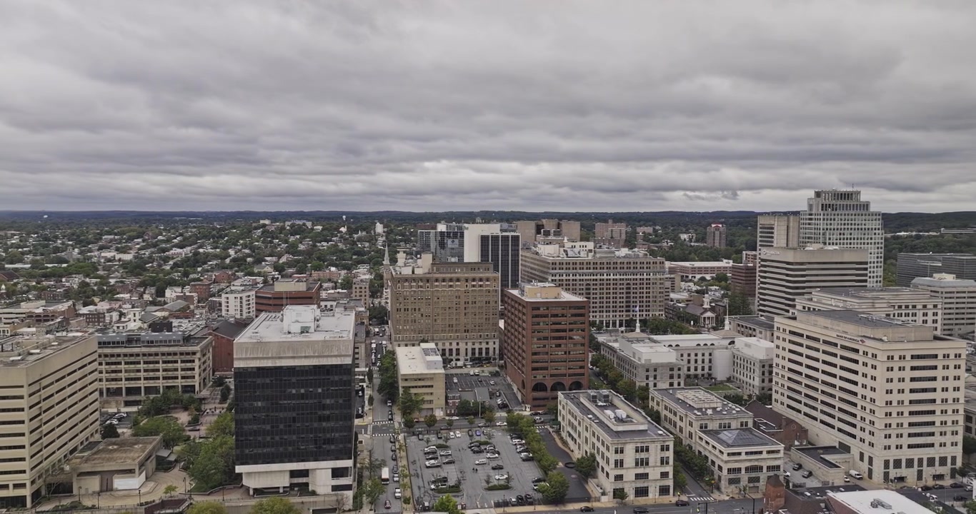 Wilmington Delaware Aerial v6 orbit from surrounding neighborhoods toward the compact downtown skyline beneath dramatic overcast clouds - Shot with Mavic 3 Pro Cine - Sept 28th 2023
