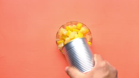 vertiendo ensalada de frutas enlatadas en un cuenco