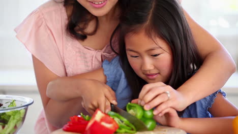 Mujer-Cortando-Un-Pimiento-Verde-Con-Su-Hija.