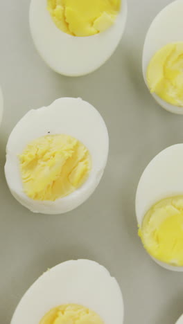 video of overhead view of halves of hard boiled eggs on grey background