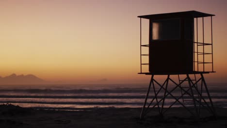 sea with waves and blue sky and lifeguard tower on beach