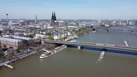 Panoramic-aerial-cityscape-of-Cologne,-Germany-in-concept-of-various-transport-modes-in-one-shot-:-Roadway,-Railway-and-waterway