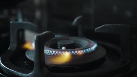 video of a black gas stove with blue and red burning flame in the kitchen