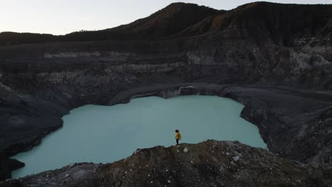 Tiro-De-Drone-De-Una-Persona-Con-Chaqueta-Amarilla-Caminando-Sobre-El-Volcán-Poas-En-Costa-Rica