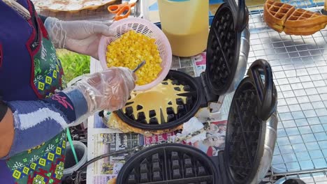 making corn and raisin waffles at a street food stall