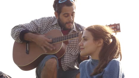 joven feliz tocando la guitarra cantando una canción de amor serenata a una mujer hermosa en el romántico parque del acueducto en roma al amanecer divertido cámara lenta