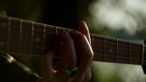 close-up of someone playing acoustic guitar outdoors