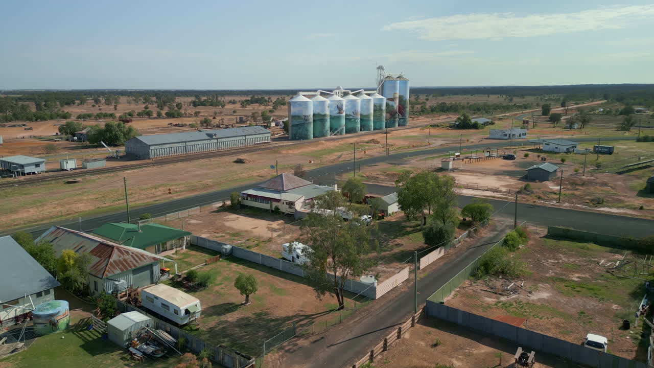 caminos de un pueblo rural en queensland, australia, icónicos silos de grano. tomada panorámica aérea de un dron, luz del día, fondo claro del horizonte.