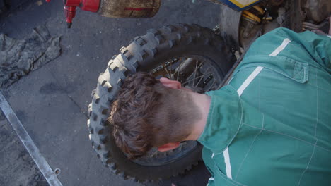 mecánico de bicicletas comprobando o reparando el sistema de frenos de la moto en el garaje