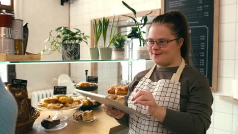 chica con síndrome de down sirviendo comida para un cliente en la mesa