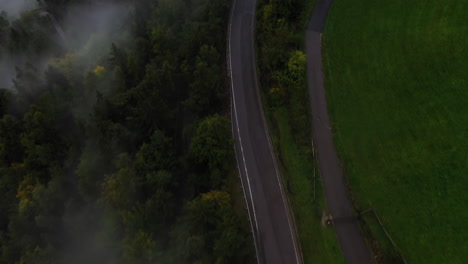 Aerial-view-following-a-misty,-mountain-road,-cloudy-morning-in-Dolomites,-Italy