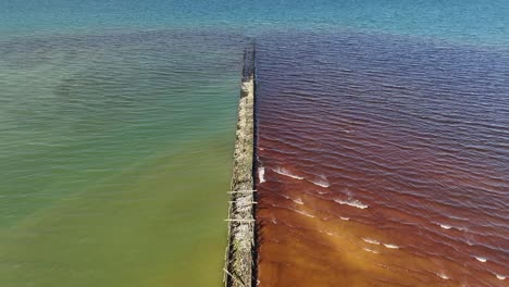 Vista-Aérea-Los-Restos-Del-Puente-Peatonal,-Que-Fue-Construido-En-El-Mar,-Fueron-Construidos-Con-Piedras-Y-Pilotes-De-Madera