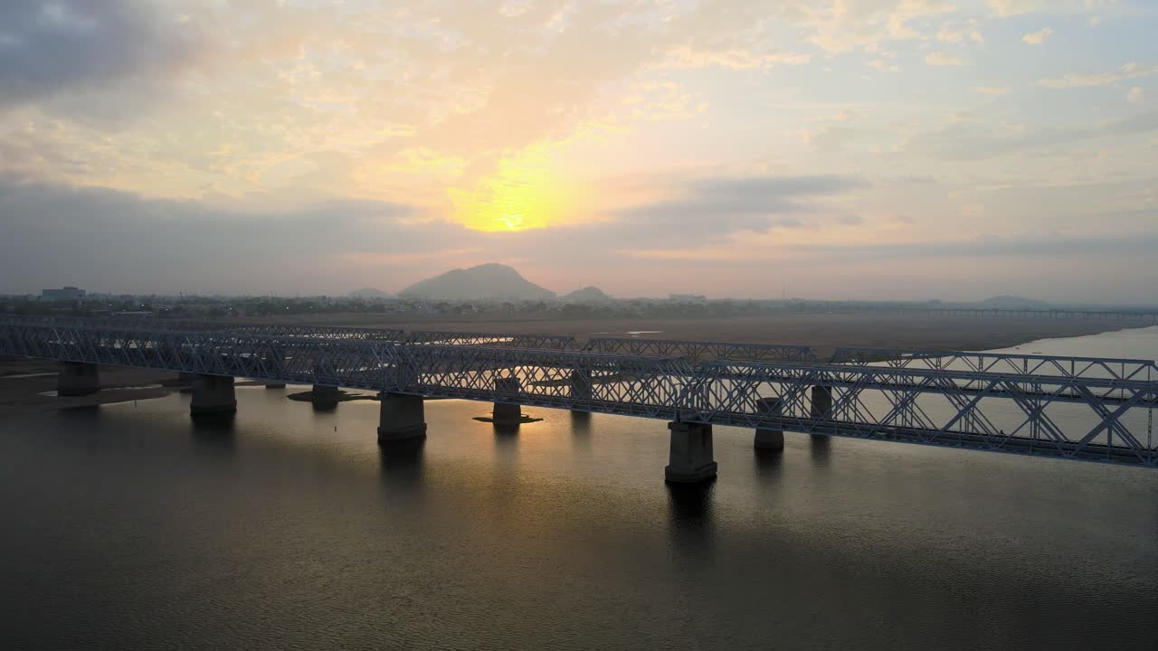 Majestic aerial drone shot of Vijayawada city during sunrise, with a view soaring above the scattered clouds.