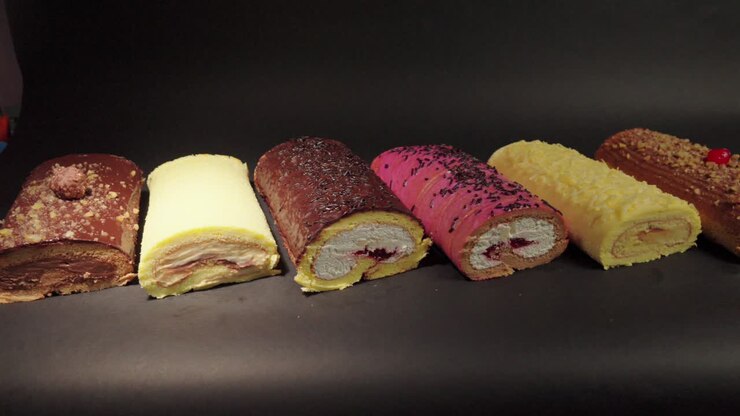rotoli di torta brazo gitano rotoli svizzeri dessert collezione cioccolato ferrero formaggio burro gelatina bacche ciliegina con sfondo nero