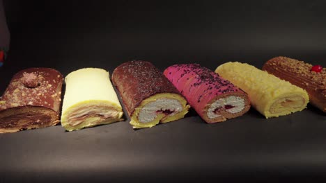 Rollos-De-Pastel-Brazo-Gitano-Rollo-Suizo-Colección-De-Postres-Chocolate-Queso-Ferrero-Mantequilla-Gelatina-Bayas-Cereza-Con-Fondo-Negro