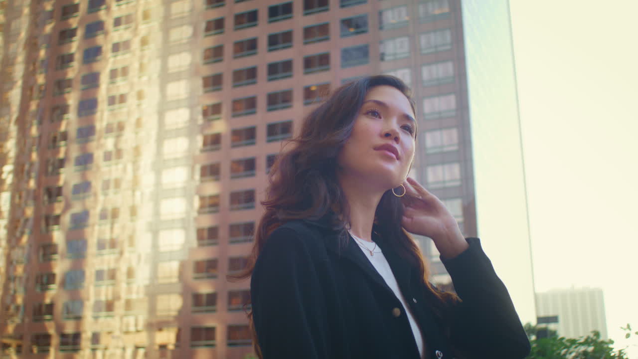 una chica linda caminando sola por la calle de la ciudad. una mujer asiática mirando alrededor en el paisaje urbano.