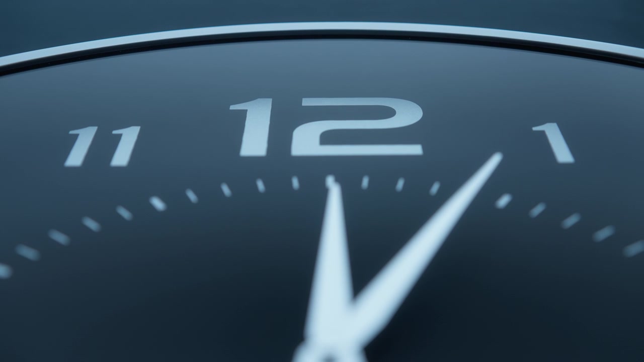 Twelve o'clock on a minimalistic black wall clock