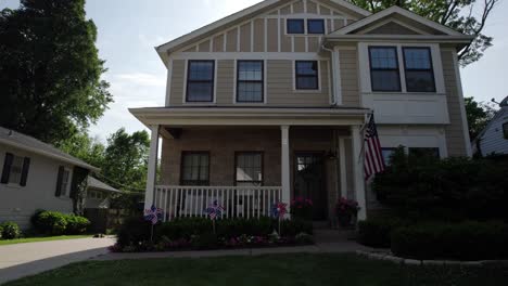 Pull-away-from-a-nice-middle-class-house-with-American-flag-and-patriotic-decorations-on-a-sunny-summer-day