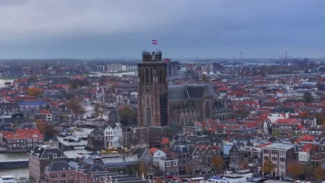 flag of netherlands flying, church shrine above the rooftops of dordrecht