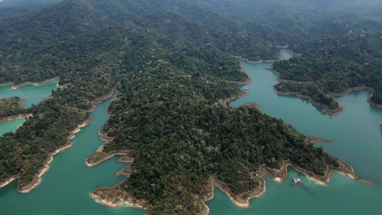 Stunning aerial views of a vast turquoise reservoir with lush forested islands and remote natural beauty