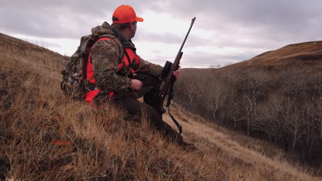 a hunter looks for prey through his binoculars near saskatchewan, canada