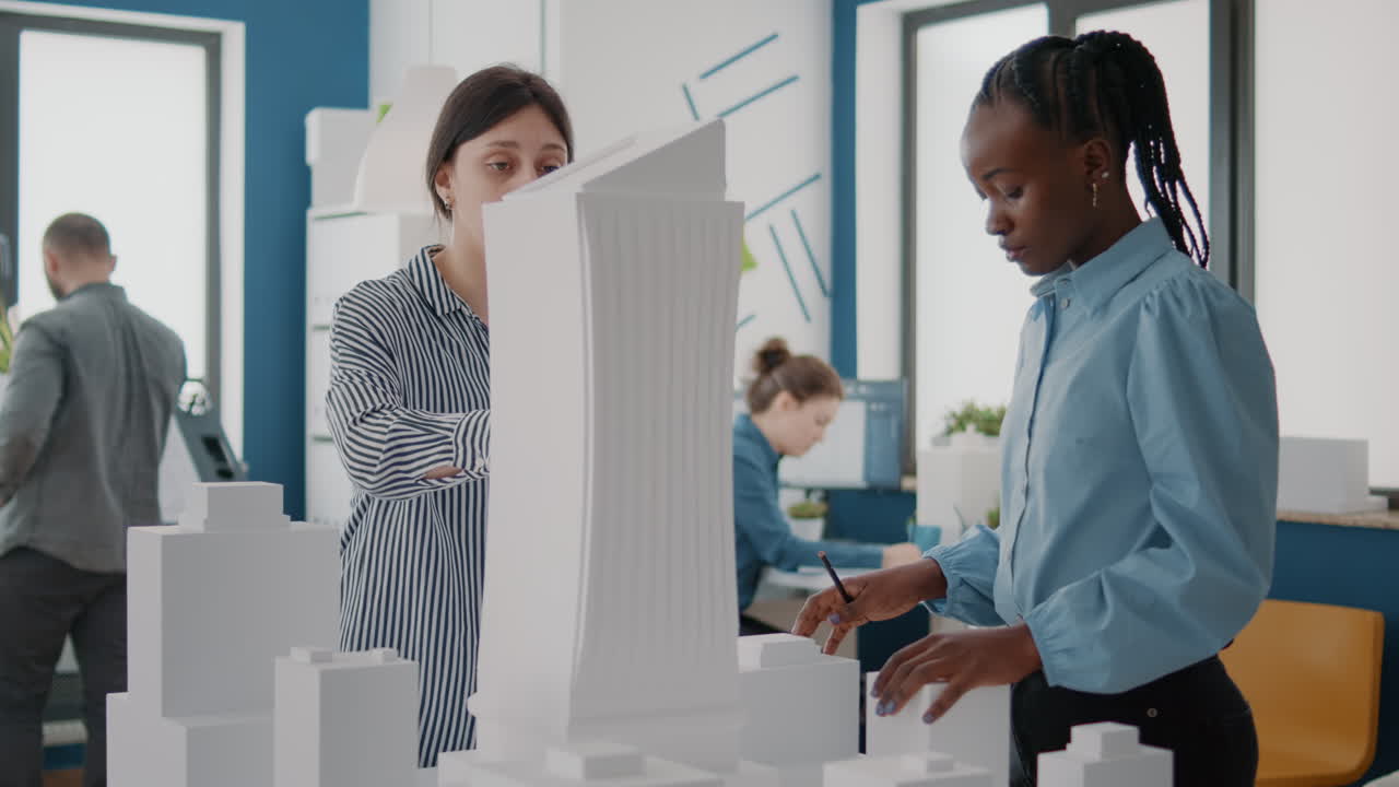 Architectural team discussing building model in office