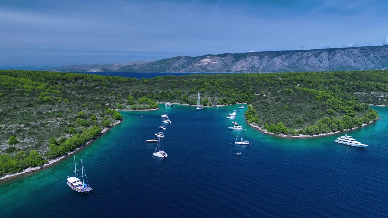 Il drone vola sopra il mare con numerose imbarcazioni ancorate vicino alla costa in Croazia. Riprese aeree 4K.