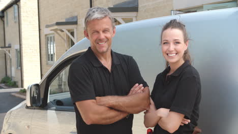 Male-and-female-trade-workers-and-their-van,-panning-up-shot