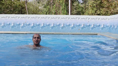 isolated young man swimming in pool with clear water at morning