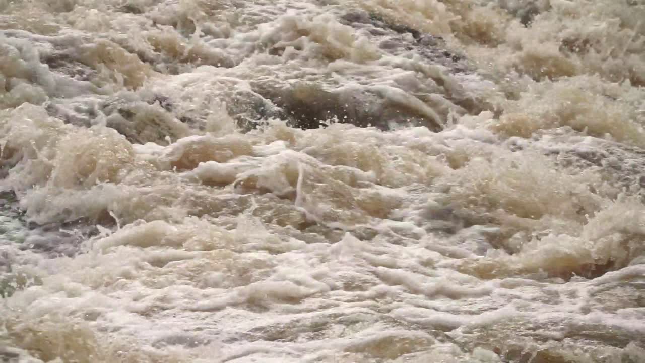 Cip of swirling, fast-flowing murky water. Splashing patterns convey a sense of urgency and natural power, suitable for scenes involving flooding, heavy rain, or wild river environments