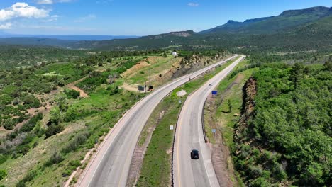 Aerial-rising-shot-of-scenic-highway-carving-through-Rocky-Mountains-in-Colorado