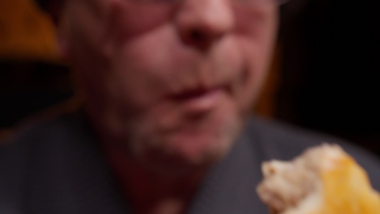 Primo piano di un uomo che mangia un dolce ripieno cremoso