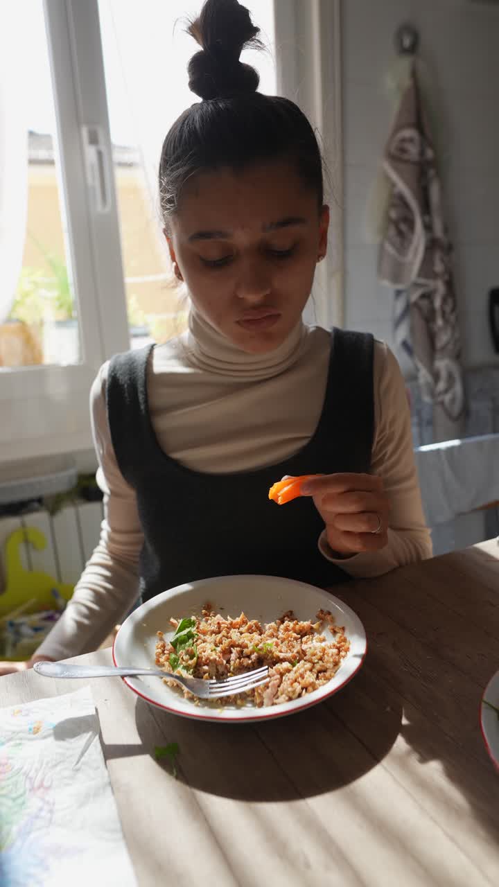 mujer comiendo una comida en una cocina
