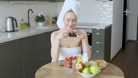 hermosa mujer con toalla en la cabeza tomando un desayuno saludable y café