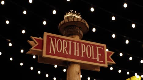 slow motion film of a sign saying "north pole" with strings of led lights filling the background of the scene at landsdowne park in ottawa, canada