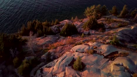 Pequeña-Carpa-Blanca-En-Una-Isla-Rocosa-En-Un-Lago-Azul,-Revelación-épica-De-Drones