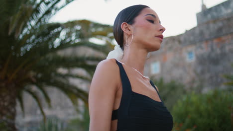 stylish woman in black dress, outdoors