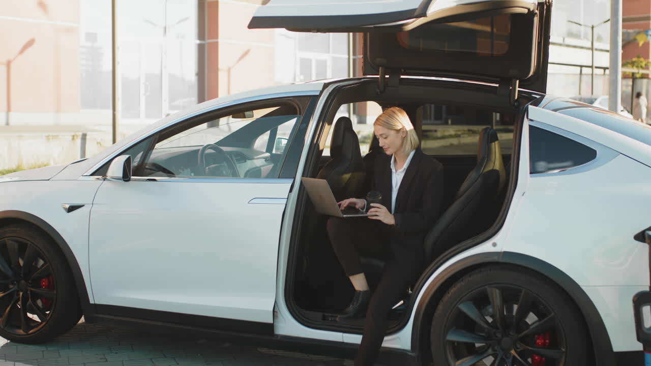 деловая женщина, работающая в электрическом автомобиле.
