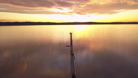 Beautiful-aerial-of-golden-sunrise-or-sunset-at-Long-Jetty-Wharf,-Central-Coast-NSW,-Sydney,-Australia