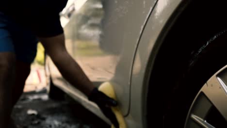 Primer-Plano-De-Un-Hombre-Lavando-Un-Auto-Usando-Guantes-Negros-Con-Champú-Y-Esponja