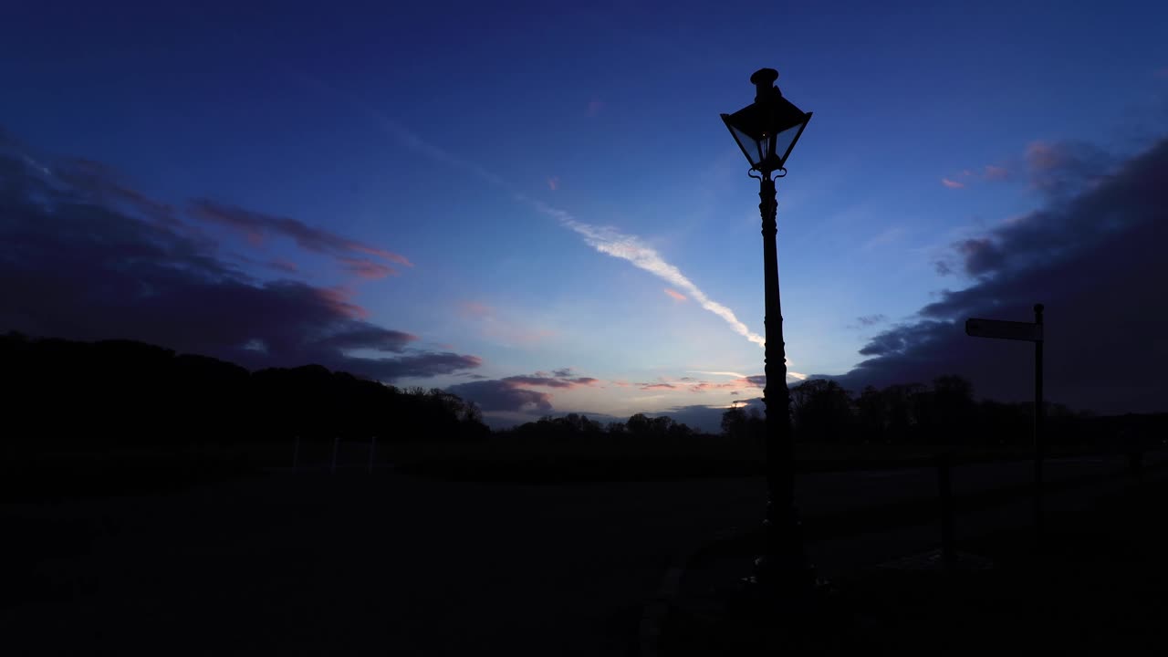 Timelapse of sunset over lamp in park Dublin