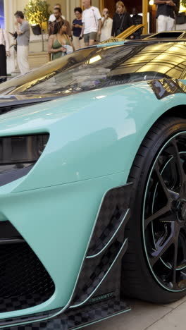 close-up of a turquoise luxury supercar at a public event
