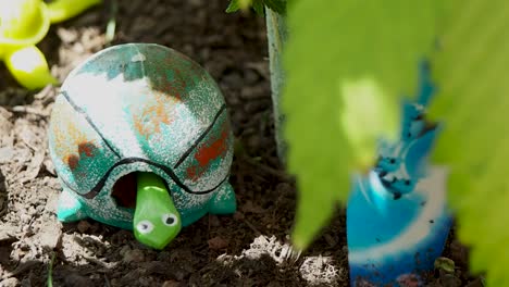 gnomos de jardín con la cabeza móvil de una tortuga en una maceta con hojas de maceta que soplan en el viento