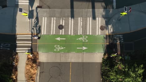 Vista-Aérea-De-Un-Ciclista-Que-Pasa-Por-Una-Intersección-Mientras-Usa-El-Carril-Bici-Designado